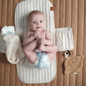 cambiador portátil abierto, en la foto se muestra con un bebé sobre él para demostrar su tamaño.